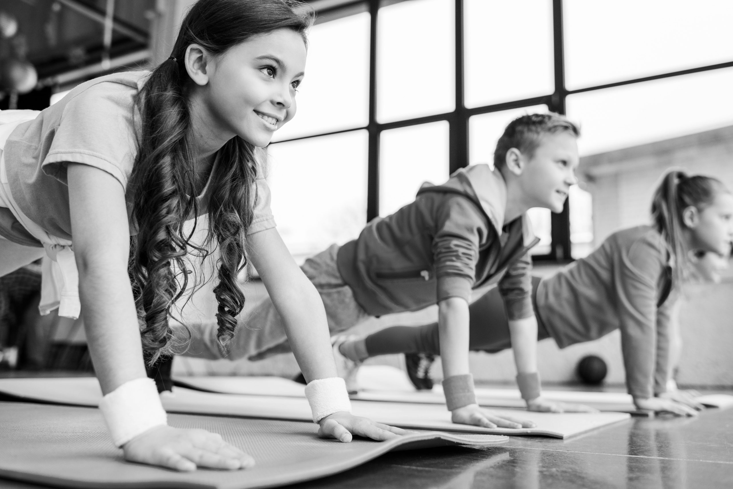BW-smiling-kids-doing-plank-exercise-on-fitness-mats-2021-09-14-21-10-39-utc